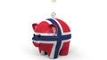 Coins fall into piggy bank painted with flag of Norway. National banking system or savings related conceptual 3D