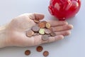 Coins falling into man& x27;s hand from upside down coin bank over white. The concept of finding money, crisis, poverty Royalty Free Stock Photo