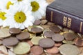Coins, flowers, and holy bible book on rustic table, Christian tithing concept Royalty Free Stock Photo