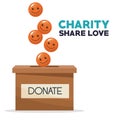 Coins in form of happy face depositing in a carton box charity share love