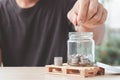 Coins in a glass bottle, Hand of male or female putting coins in jar with money stack step growing growth saving money Royalty Free Stock Photo