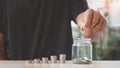 Coins in a glass bottle, Hand of male or female putting coins in jar with money stack step growing growth saving money on nature b Royalty Free Stock Photo