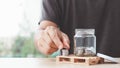 Coins in a glass bottle, Male hand putting coin with money stack step growing growth saving money, Royalty Free Stock Photo