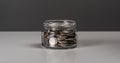 Coins in glass jar. currency money on dark gray background for business and finance concept Royalty Free Stock Photo