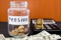 Coins in a glass jar, dollars and calculator on black. Saving money. Pension concept. Royalty Free Stock Photo