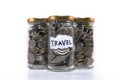 Coins in a glass jar labeled ` TRAVEL ` on a white background. Royalty Free Stock Photo