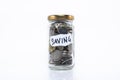 Coins in a glass jar with note written ` SAVING ` Royalty Free Stock Photo