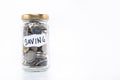 Coins in a glass jar with note written ` SAVING ` on white background. free copy space. Royalty Free Stock Photo