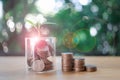 Coins in a glass jar with the small tree on top and coin ladder on table Royalty Free Stock Photo