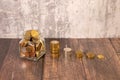 Coins in a glass jar with the small tree on top and coin ladder on table. Glass jar money saving Royalty Free Stock Photo