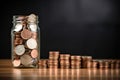 Coins in a glass jar on a wooden table and black background, Growing stacks of coins and a jar of coins on a table, AI Generated