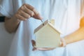 Coins with hand putting of coin on home model bank,Finance and money saving concept Royalty Free Stock Photo