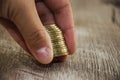 Coins in hand on a wooden table background, close-up. Royalty Free Stock Photo