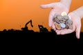 Coins in hands on Industry silhouette Landscape background Royalty Free Stock Photo