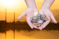 Coins in hands on Industry silhouette Landscape background Royalty Free Stock Photo