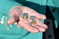 The coins are in the hands of the old lady. An elderly woman with money in her hands. Poverty alms