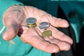 The coins are in the hands of the old lady. An elderly woman with money in her hands. Poverty alms