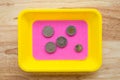 Coins of the Japanese yen in colorful coin tray on wooden table