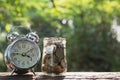 Coins in jar with alarm clock on nature background, Concept finance business, saving investment and accounting concept. Royalty Free Stock Photo