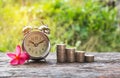 Coins in jar with money stack step growing money and alarm clock Royalty Free Stock Photo