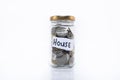 Coins in a jar with a note written ` HOUSE `. on a white background.