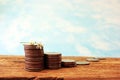 Coins located on a wooden table in stacks in ascending order, a flower as a symbol of business prosperity. Business concept