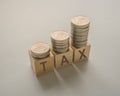 income tax increase with coins money stack on wooden cubes on a table Royalty Free Stock Photo