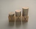 income tax increase with coins money stack on wooden cubes on a table Royalty Free Stock Photo