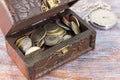 Coins in an old wooden box Royalty Free Stock Photo