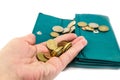 Coins in a palm and a green female purse. White background. Close-up. Royalty Free Stock Photo