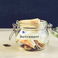 Coins and paper money in a glass jar on wooden table against dar Royalty Free Stock Photo