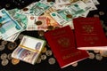 Coins and paper money and two international passports lie on a black wooden table Royalty Free Stock Photo