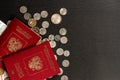 Coins and paper money and two international passports lie on a black wooden table Royalty Free Stock Photo