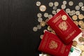 Coins and paper money and two international passports lie on a black wooden table Royalty Free Stock Photo