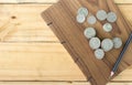 Coins and Pencil on handmade book on wood table