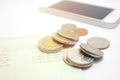 Coins and phone on account book bank for finance and banking. Royalty Free Stock Photo