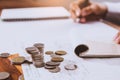 Coins placed on a pile of money saving on the table. businessman Writing paper and Calculating bonus Royalty Free Stock Photo