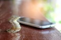 Coins with smart phone place on wooden floor. Royalty Free Stock Photo