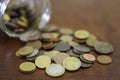 Coins spilling from a glass jar Royalty Free Stock Photo