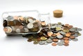 Coins spilling out of a glass jar. Royalty Free Stock Photo