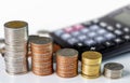 Coins stack with a calculator on white background. The concept of business growth, financial or money savings, with copy space for Royalty Free Stock Photo