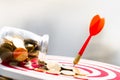 Coins stack and darts arrow hitting in the target center of dartboard. Royalty Free Stock Photo