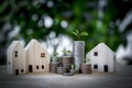 Coins stack and houses model with green bokeh background.