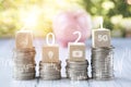 Coins stack and number 2021 on square wood and Medical treatment icon on nature background, Money spending planning, plant growing Royalty Free Stock Photo