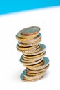 Coins stacked on each other in different positions on a blue and white background