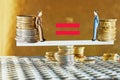 Coins are stacked on top of each other with figures of business people on the scales, market crisis and fragile market Royalty Free Stock Photo