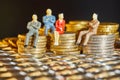 The coins are stacked on top of each other with the figures of business people sitting on them, a market crisis and a fragile Royalty Free Stock Photo