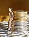 Coins stacked on top of each other with a human figure, close-up, market crisis and fragile market Royalty Free Stock Photo