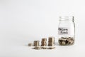 Coins stacked up next to an empty jar with a label on for pension fund. Pension, financial, savings, economy, investment concept Royalty Free Stock Photo