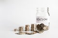 Coins stacked up next to an empty jar with a label on for pension fund. Pension, financial, savings, economy, investment concept Royalty Free Stock Photo